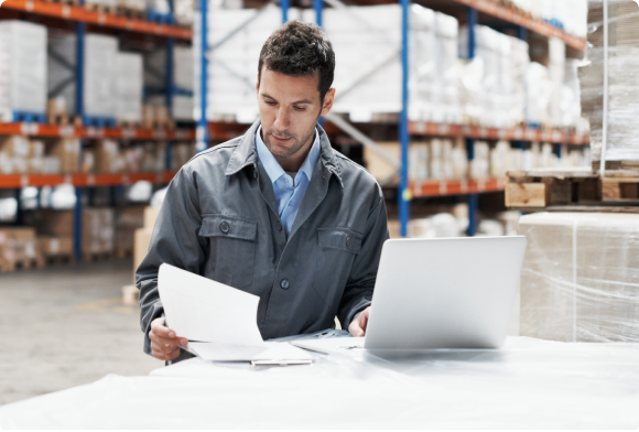 Warehouse worker checks inventory on computer